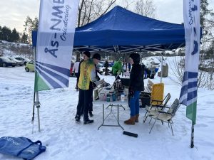 Folk melder seg på til løp, ved et telt.